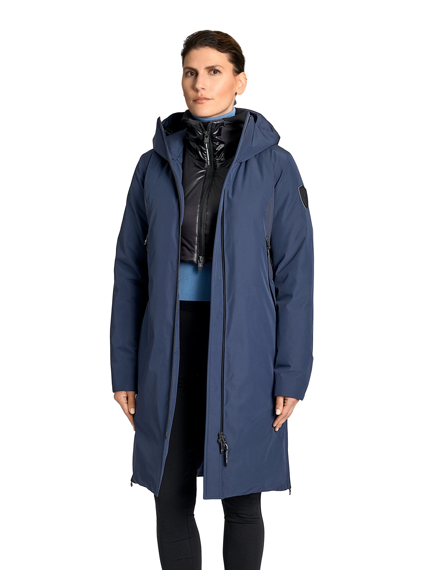Inara Women's Performance Parka in knee length, premium 3-ply micro denier and stretch ripstop fabrication with DWR coating, Premium Canadian White Duck Down insulation, non-removable down-filled hood, centre front two-way zipper, large vertical zipper pockets along waist, zipper vents along bottom side hem, in Marine