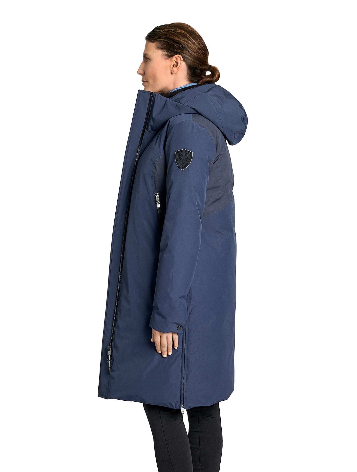 Inara Women's Performance Parka in knee length, premium 3-ply micro denier and stretch ripstop fabrication with DWR coating, Premium Canadian White Duck Down insulation, non-removable down-filled hood, centre front two-way zipper, large vertical zipper pockets along waist, zipper vents along bottom side hem, in Marine