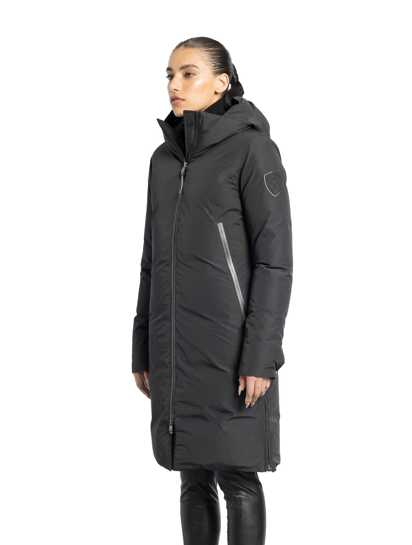 Inara Women's Performance Parka in knee length, premium 3-ply micro denier and stretch ripstop fabrication with DWR coating, Premium Canadian White Duck Down insulation, non-removable down-filled hood, centre front two-way zipper, large vertical zipper pockets along waist, zipper vents along bottom side hem, in Black