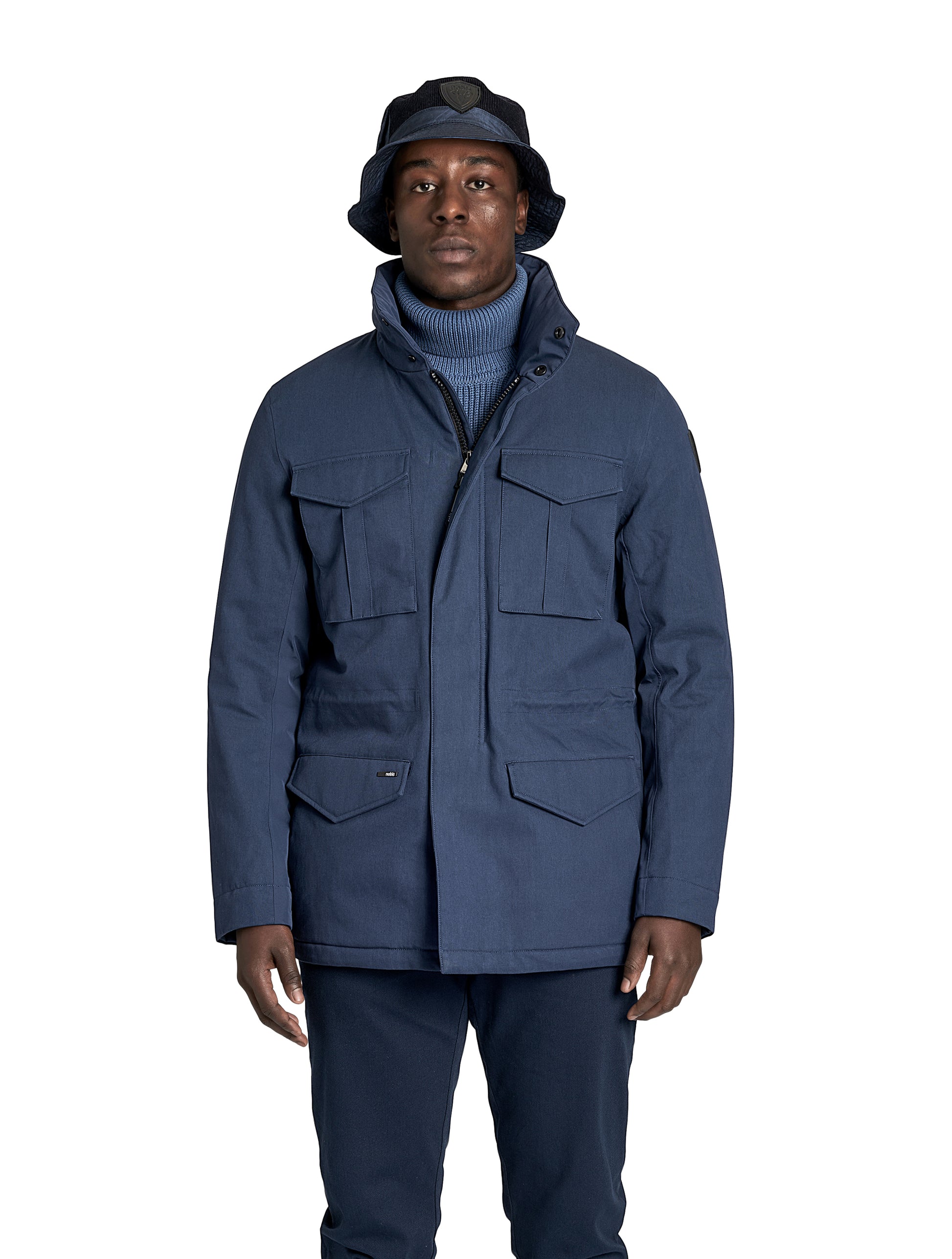 Pelican Men's Tailored Field Jacket in hip length, premium cotton blend and 3-ply micro denier fabrication, Premium Canadian origin White Duck Down insulation, tuck away, waterproof hood in premium cire technical nylon taffeta, two-way centre-front zipper with magnetic wind flap, pit zipper vents, magnetic closure chest and waist flap pockets, hidden adjustable waist drawcord, and action back detailing, in Navy