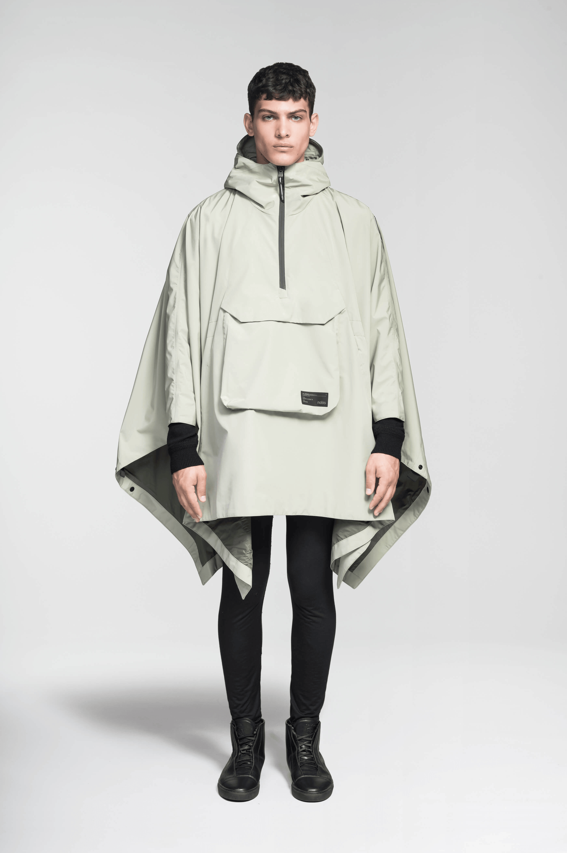 Hydra Unisex Performance Poncho in thigh length, non-removable hood, vertical half-zipper along centre front collar, hidden side-entry waist zipper pockets, adjustable webbing straps and snap closure cuffs, and packable to front kangaroo pocket with flap opening, in Tea