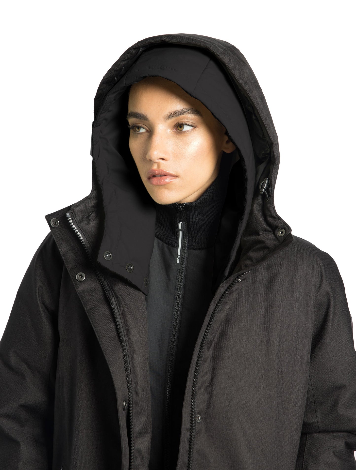 Dory Women's Tailored Back Zip Parka in knee length, premium Crosshatch fabrication, Premium Canadian White Duck Down insulation, non-removable down-filled hood, removable interior hood, centre front two-way zipper with wind flap, vertical zipper detailing along back, in Black