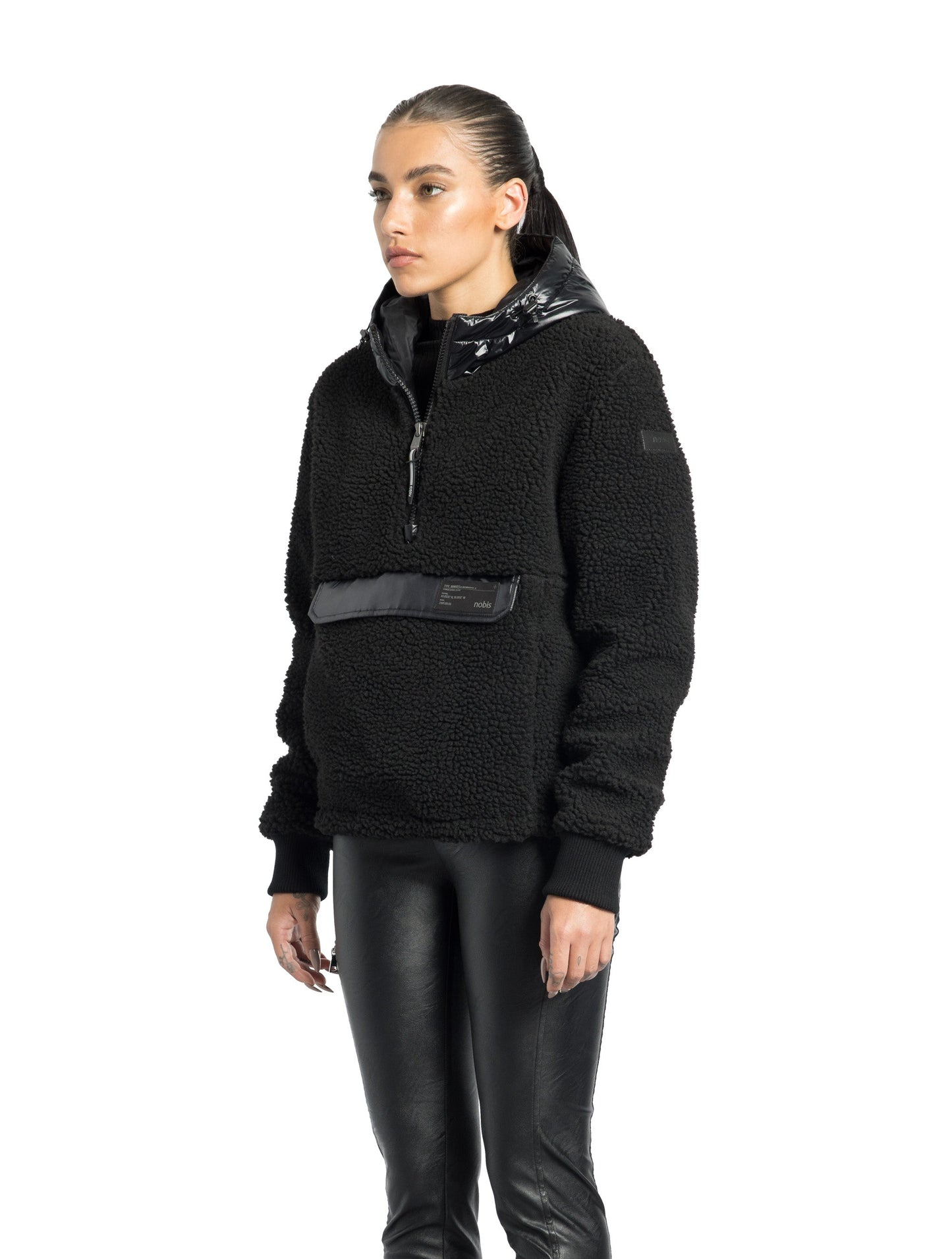 Roche Women's Hybrid Berber Pullover Hoodie in hip length, premium berber and cire technical nylon taffeta fabrication, Primaloft Gold Insulation Active+, non-removable hood with zipper at collar, kangaroo pocket with magnetic closure flap and additional side-entry pockets, ribbed cuffs, adjustable drawcords at side hem, in Black