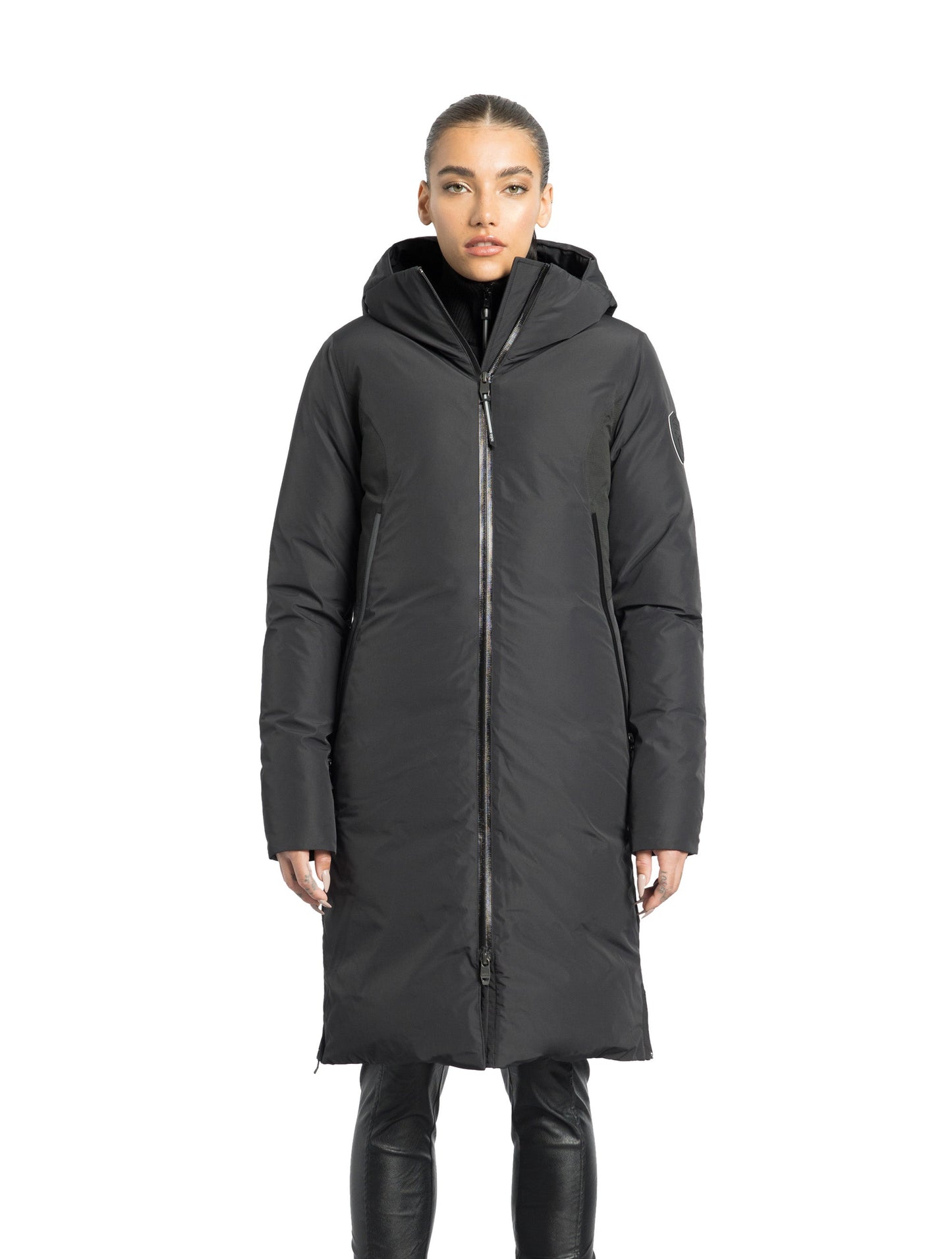 Inara Women's Performance Parka in knee length, premium 3-ply micro denier and stretch ripstop fabrication with DWR coating, Premium Canadian White Duck Down insulation, non-removable down-filled hood, centre front two-way zipper, large vertical zipper pockets along waist, zipper vents along bottom side hem, in Black