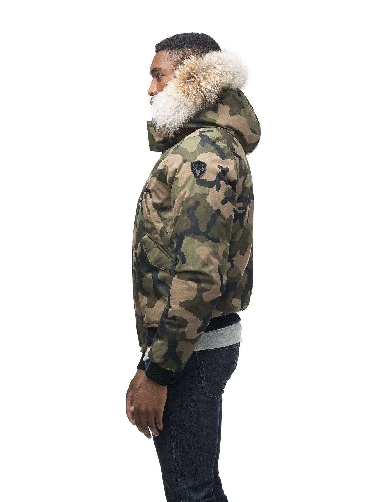Men's classic down filled bomber jacket with a down filled hood that features a removable coyote fur trim and concealed moldable framing wire in Camo